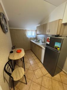 a small kitchen with a table and a refrigerator at Dora sarti in Sarti
