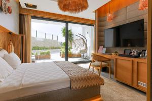 a bedroom with a bed and a desk and a television at Cesme Sarezya Luxury Boutique Hotel in Çeşme