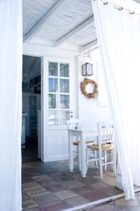 a white dining room with a white table and chairs at White Blue Villa formerly Ippocampi in Koutouloufari