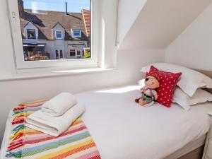 a small bedroom with a bed with a window at Dunford Cottage in Bamburgh