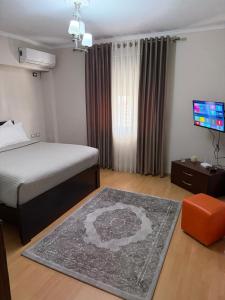 a bedroom with a bed and a flat screen tv at Cozy City Studio in Gjirokastër