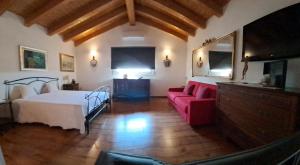 a bedroom with a bed and a red couch at Villa Posta Vecchia in Loreo +40 photos