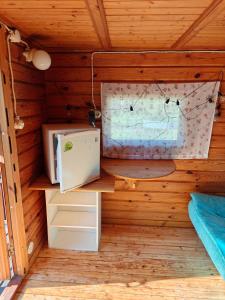 a room in a cabin with a refrigerator and a window at Mökki upealla maisemalla in Kouvola