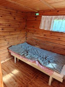 a room with a bed in a wooden cabin at Mökki upealla maisemalla in Kouvola