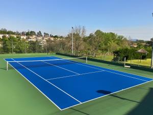 a tennis court with a blue tennis court at Quinta Dom José Turismo Rural in Braga