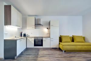 a kitchen with white cabinets and a yellow couch at Ladurnhof in Silandro +43 photos