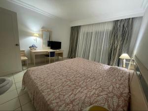 a hotel room with a bed and a desk at Yasmina Hotel Appartment in Yasmine +14 photos