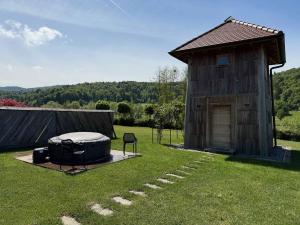 a wooden building with a tub in the grass at Hiska Ulala in Dob