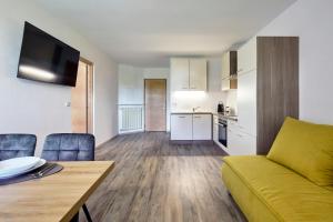 a living room with a couch and a table and a kitchen at Ladurnhof in Silandro
