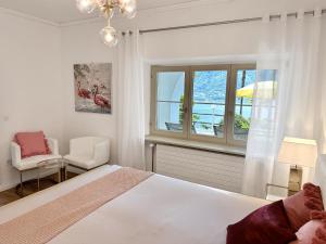 a bedroom with a bed and a chair and a window at Villa Grande Dame by Fewotessin in Minusio +51 photos