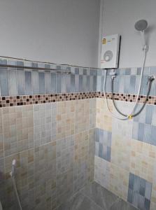 a shower in a bathroom with blue and brown tiles at จันผารีสอร์ท By NLG in Ban Khok Khian