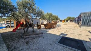 a park with a playground with a swing at Rilux Mobile Home "Camping Pirovac" in Pirovac