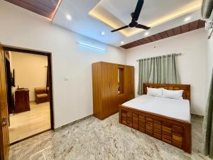 a bedroom with a bed and a ceiling fan at Tri Riverfront Homestay in Udupi