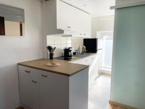 a kitchen with white cabinets and a counter top at 1 appartement au centre de Saignelégier in Saignelégier