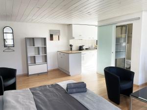 a bedroom with a large bed and a kitchen at 1 appartement au centre de Saignelégier in Saignelégier
