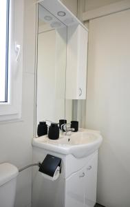 a white bathroom with a sink and a mirror at Rilux Mobile Home "Camping Pirovac" in Pirovac +13 photos