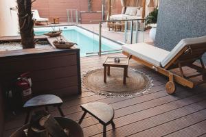 a room with a pool and a bed and chairs at TULUM luxury suites-SKOPJE in Skopje
