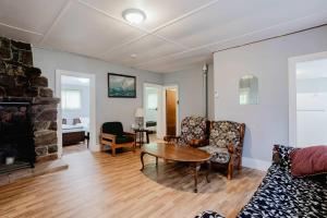 a living room with a couch and a table and a fireplace at 3-Bedroom Cottage #7 - Ambleside in Kawartha Lakes