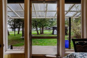 an open glass door with a view of a yard at 3-Bedroom Cottage #7 - Ambleside in Kawartha Lakes