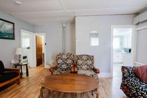 a living room with a table and a chair at 3-Bedroom Cottage #7 - Ambleside in Kawartha Lakes +24 photos
