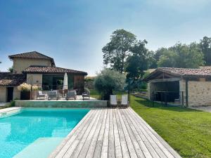 a house with a swimming pool and a wooden deck at Barbarens Maison d'hotes in Castelnau-Barbarens