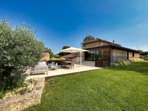 a house with a patio with a table and chairs at Barbarens Maison d'hotes in Castelnau-Barbarens