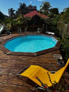 a swimming pool on a wooden deck with an umbrella at Cerise in Sainte-Anne
