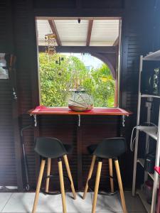 a small kitchen with a table and two stools at Cerise in Sainte-Anne +2 photos