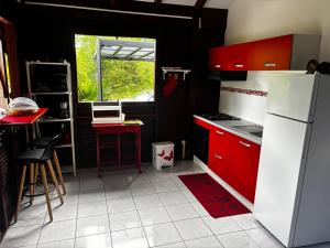 a kitchen with red cabinets and a white refrigerator at Cerise in Sainte-Anne
