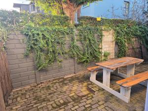 a wooden picnic table sitting in front of a brick wall at In Vrede in George +7 photos