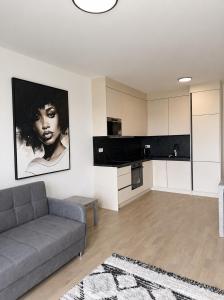 a living room with a couch and a kitchen at SunsetSkylineApartment in Nivy