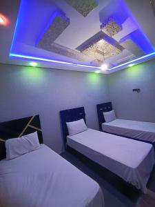 two beds in a room with a blue light at Toubkal Guesthouse in Imlil