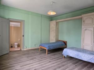 a room with two beds and a bench in it at Gîte VINCENT in Château-Salins