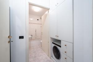a white bathroom with a washer and dryer at Lake Como - Front Station - Lake at 2 min - Wifi in Lecco