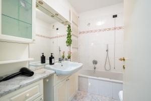a white bathroom with a sink and a bath tub at Lake Como - Front Station - Lake at 2 min - Wifi in Lecco +15 photos