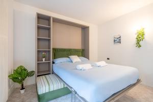a bedroom with a large white bed and a plant at Lake Como - Front Station - Lake at 2 min - Wifi in Lecco