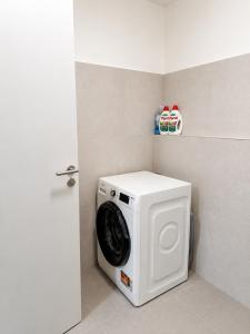 a washing machine in a corner of a room at SunsetSkylineApartment in Nivy