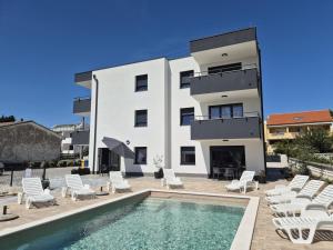 a villa with a swimming pool and a building at Apartment Natalija A2 ground floor in Krk