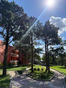 a group of trees in front of a building at Peko's Multiparque Hotel in Villa Santa Cruz del Lago