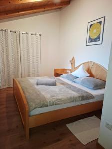 a bedroom with a bed with a wooden frame at Mareinhof - Urlaub auf dem Apfelbauernhof in Parcines