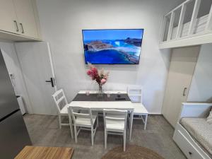 a dining room with a white table and white chairs at Little Gem -A Cycladic Aura- Serifos in Serifos Chora +8 photos