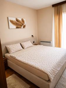 a bedroom with a bed and a window at Duma Apartmani Vrnjačka Banja in Vrnjci +23 photos