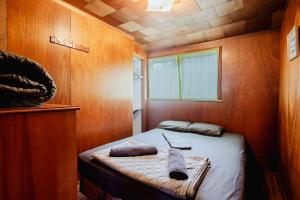 a small room with a bed in a wooden room at Ambleside - 2-Bedroom Cottage #8 in Kawartha Lakes