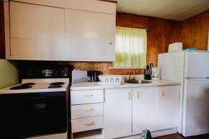 a kitchen with white cabinets and a white refrigerator at Ambleside - 2-Bedroom Cottage #8 in Kawartha Lakes +11 photos