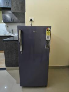 a blue refrigerator with a sticker on it in a kitchen at Stayvora Nest in Bangalore