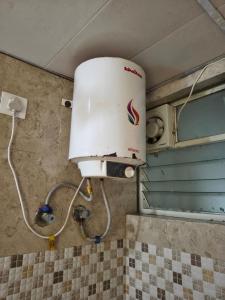 a water tank on the wall of a bathroom at Stayvora Nest in Bangalore
