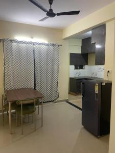 a kitchen with a table and a black refrigerator at Stayvora Nest in Bangalore +8 photos