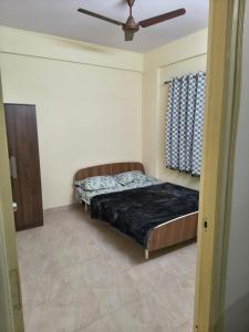 a bedroom with a bed and a ceiling fan at Stayvora Nest in Bangalore