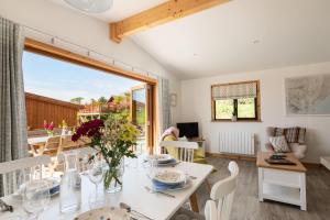 a dining room and living room with a table and chairs at L56 - Seaglass in Truro