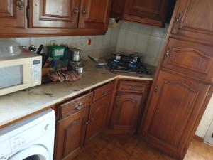 a kitchen with wooden cabinets and a white microwave at apartamento com varios quartos in Coimbra